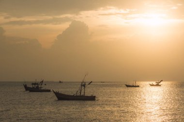 Deniz kenarındaki güzel bir gün batımı ile tekneler