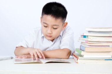 Asyalı Çinli küçük çocuk öğrenci üniforma okuma Textboo giyiyor