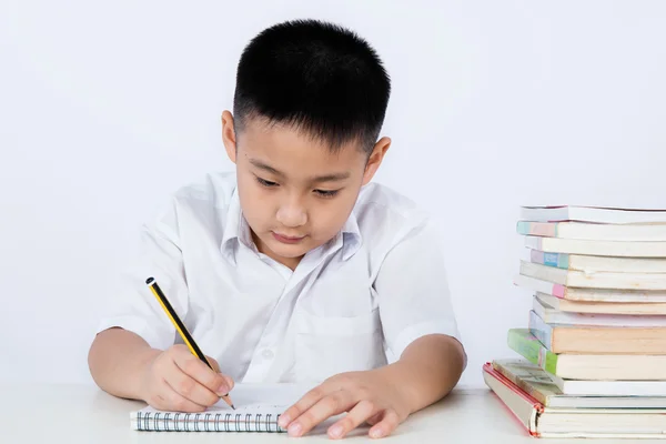 Asiático chinês pequeno menino vestindo estudante uniforme escrito homewo — Fotografia de Stock