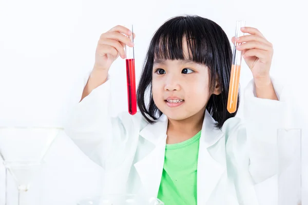 Leende asiatisk kinesisk liten flicka att undersöka provrör med Uniform — Stockfoto