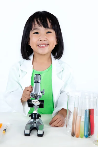 Χαμογελώντας Ασιατική Κινέζικη κοριτσάκι εργάζονται με μικροσκόπιο — Φωτογραφία Αρχείου