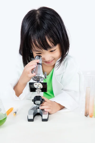 Sonriente asiática china niña trabajando con microscopio — Foto de Stock