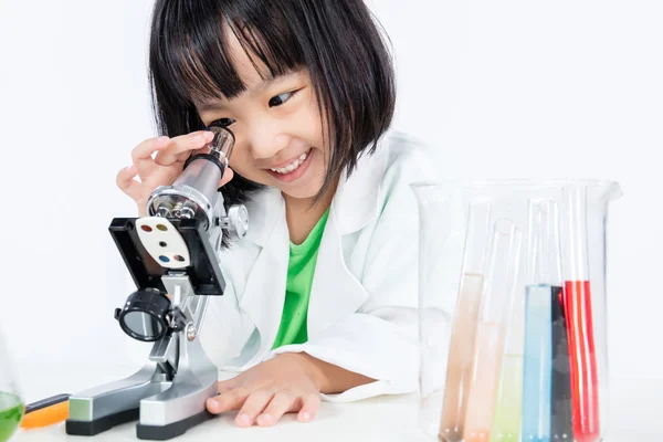 Χαμογελώντας Ασιατική Κινέζικη κοριτσάκι εργάζονται με μικροσκόπιο — Φωτογραφία Αρχείου