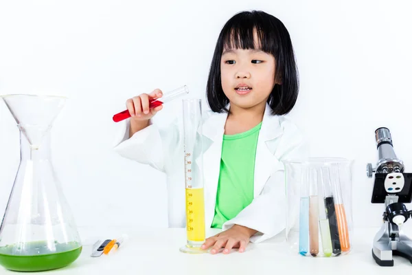 Asiatiska kinesiska liten flicka att undersöka provrör med Uniform — Stockfoto