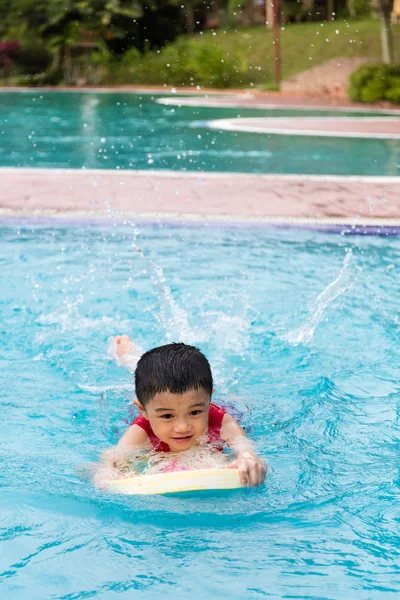 Asiático chinês menino nadando com flutuante bordo — Fotografia de Stock