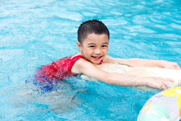 Menino chinês asiático feliz nadando com placa flutuante — Fotografia de Stock