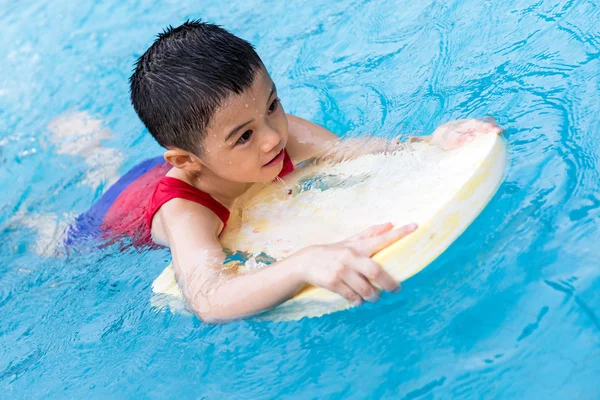 Asiático chinês menino nadando com flutuante bordo — Fotografia de Stock