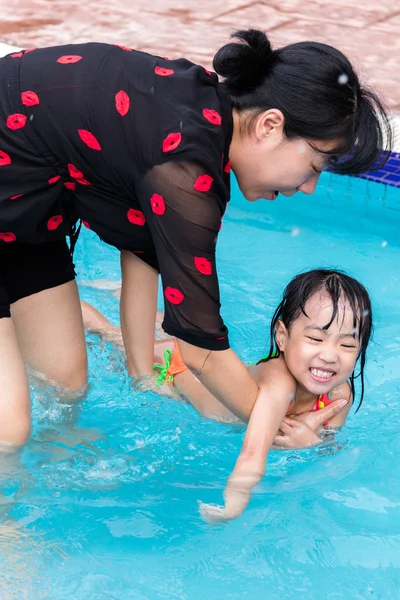 Asiática china mamá enseñando poco chica natación en la piscina — Foto de Stock