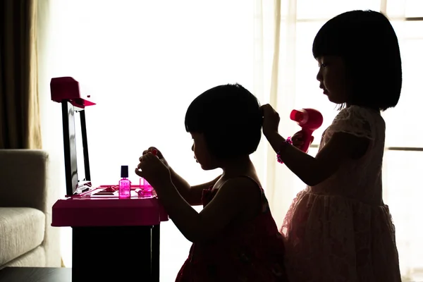Silhouet Aziatische Chinese Liitle zusters spelen met speelgoed van de Make-Up — Stockfoto