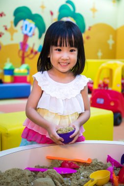 Mutlu Asyalı Çinli küçük kız Kinetik kum kapalı oynamaya