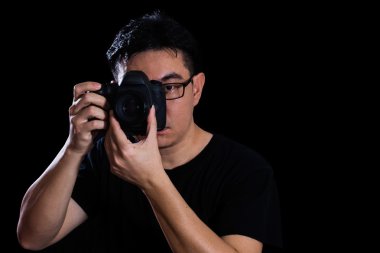 Asyalı Çinli erkek fotoğrafçı dijital Slr kamera tutarak