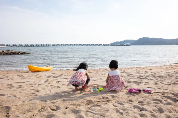 Ázsiai kínai kishúga játék homok a tengerparton — Stock Fotó