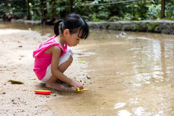 Asiático chinês menina jogar brinquedo barco no riacho — Fotografia de Stock