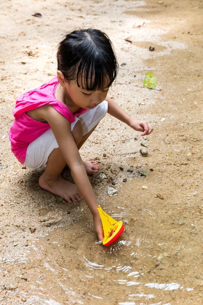 Asiático chinês menina jogar brinquedo barco no riacho — Fotografia de Stock