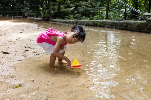 Asiático chinês menina jogar brinquedo barco no riacho — Fotografia de Stock