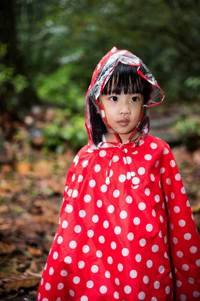 Asiática china niña usando impermeable en el bosque —  Fotos de Stock
