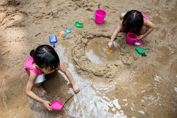 Asiático chinês pouco irmã jogar areia no riacho — Fotografia de Stock