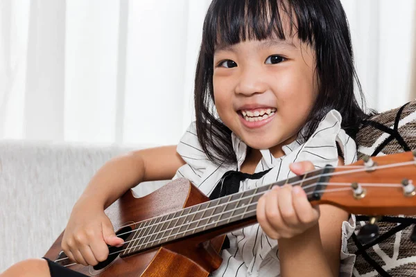 Szczęśliwy azjatycki chiński dziewczynka gra ukele — Zdjęcie stockowe