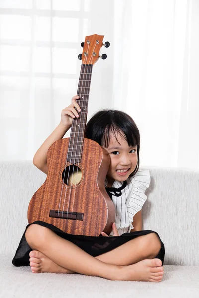 Szczęśliwy azjatycki chiński dziewczynka gra ukele — Zdjęcie stockowe