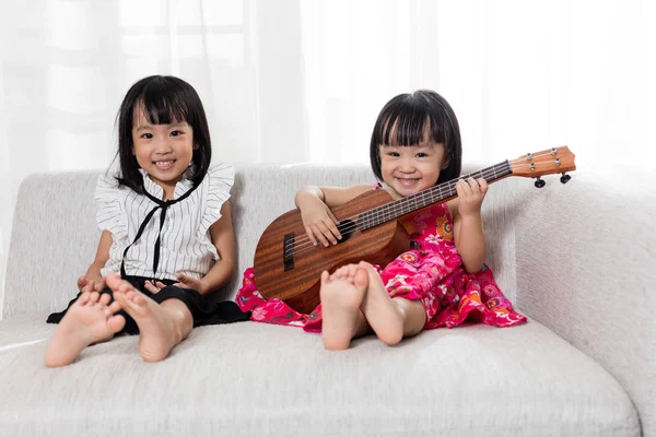 Asiática china pequeña hermana jugando ukele —  Fotos de Stock