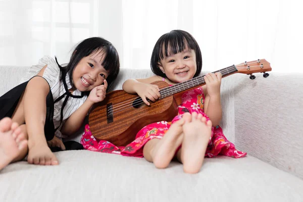 Asiática china pequeña hermana jugando ukele —  Fotos de Stock