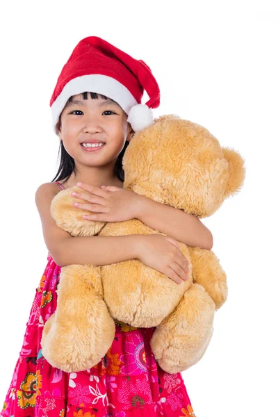 亚洲中国的小女孩穿着圣诞老人帽子控股泰迪熊 — 图库照片