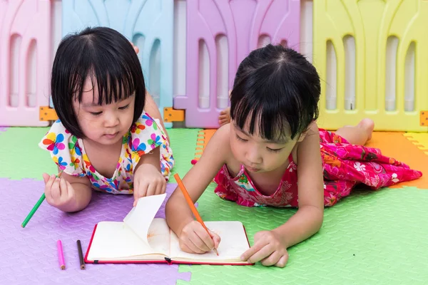 Asiatische chinesische kleine Schwestern legen auf die Boden-Färbung — Stockfoto