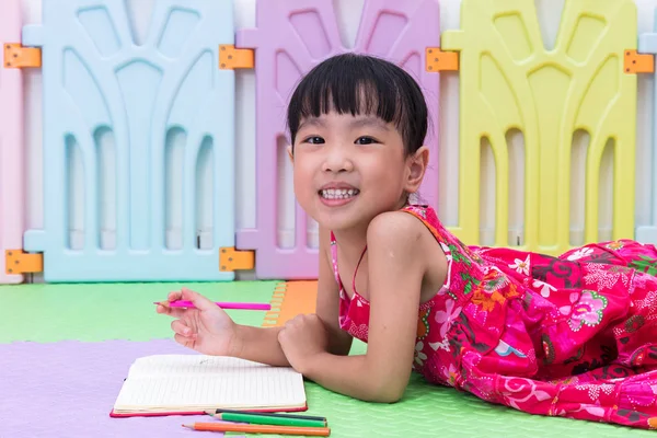 Gelukkig Aziatische Chinese meisje opleggen aan de kleuren van de vloer — Stockfoto