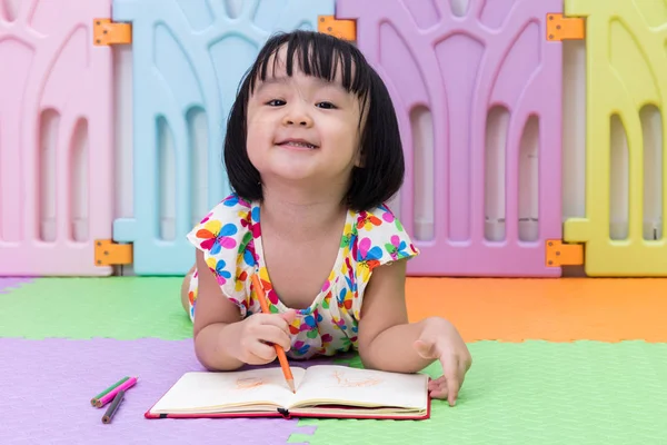 Felice asiatico cinese bambina posa sul pavimento da colorare — Foto Stock