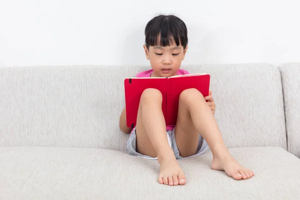 Asiática china niña sentada en el sofá con libro — Foto de Stock