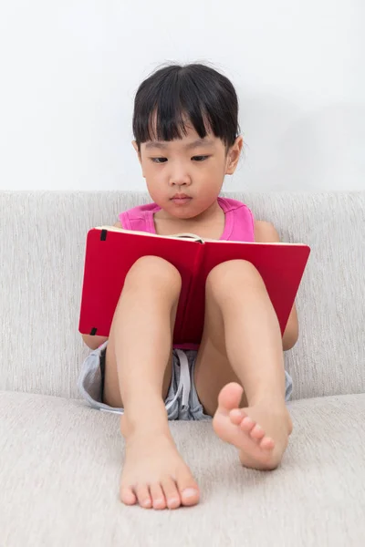 Asiatisch chinesisch klein mädchen sitting auf die sofa mit buch — Stockfoto