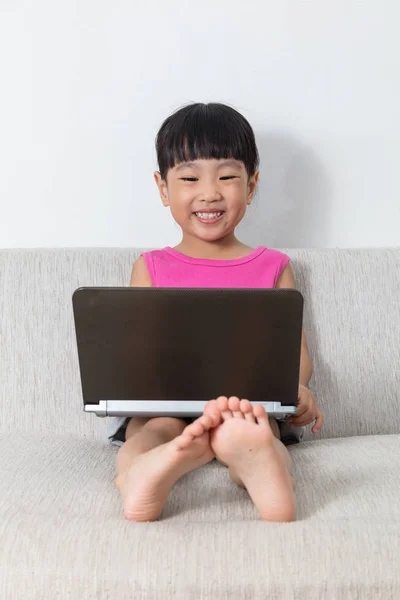 Feliz asiática china niña sentada en sofá con portátil — Foto de Stock