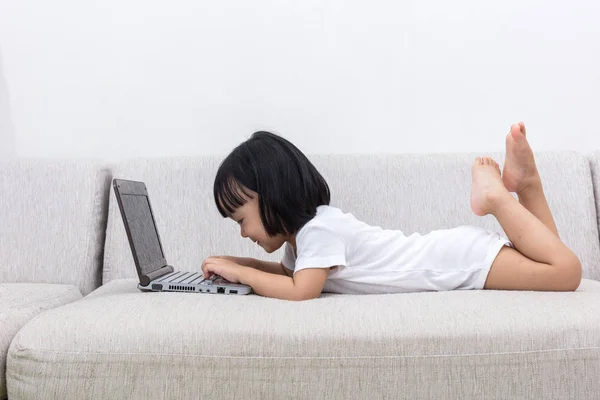 Asiática china niña acostada en el sofá utilizando el ordenador portátil — Foto de Stock
