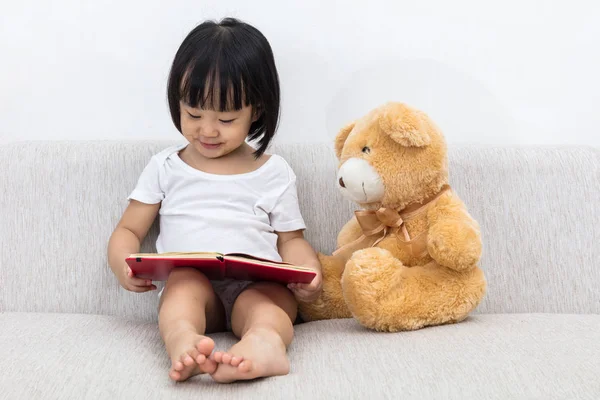 Asiática china niña leyendo libro con osito de peluche — Foto de Stock