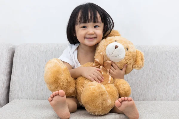 Glad asiatiska kinesiska liten flicka kramar en nallebjörn — Stockfoto
