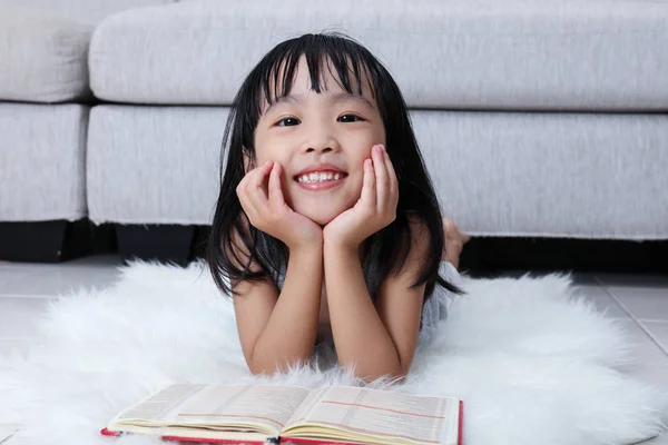 Feliz asiática china niña leyendo libro en el suelo — Foto de Stock