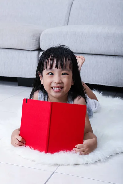 Szczęśliwy azjatycki chiński dziewczyna czytania książeczkę na podłodze — Zdjęcie stockowe