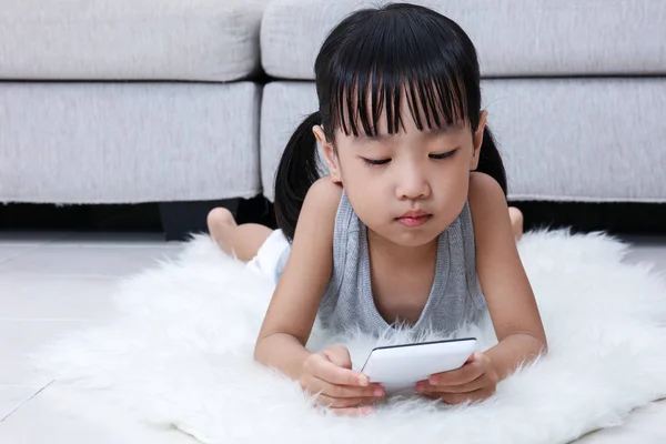 Azjatycki chiński dziewczynka grający telefon na podłodze — Zdjęcie stockowe