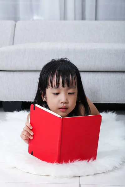 Asiatisch chinesisch klein mädchen reading buch auf die boden — Stockfoto