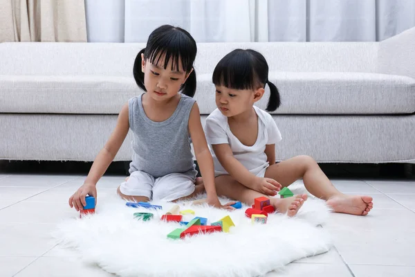 Asiatiska kinesiska små systrar spela block på golvet — Stockfoto