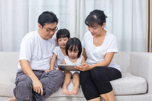 Aziatische Chinese ouders en dochters met behulp van de tablet op de Bank — Stockfoto