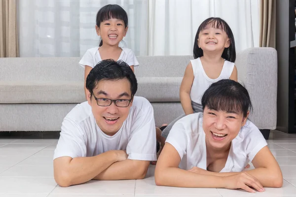 Gelukkige Aziatische Chinese ouders en dochters op de vloer liggen — Stockfoto