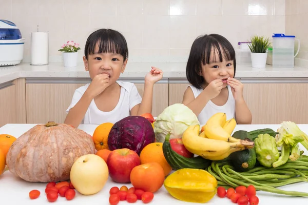 Feliz asiática china hermanitas comiendo frutas y verduras — Foto de Stock