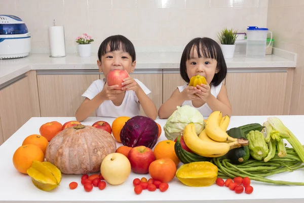 Feliz asiática china hermanitas comiendo frutas y verduras — Foto de Stock