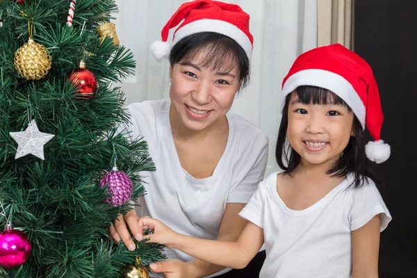 Азиатская мать и дочь украшают елку в h — стоковое фото