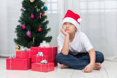 Asyalı Çinli küçük çocuk Noel ile sıkılmış ifade gösterilen