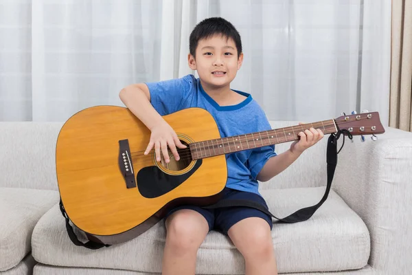 Gelukkig Aziatische Chinese jongetje met gitaarspelen op de Bank — Stockfoto