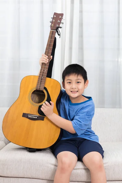 Gelukkig Aziatische Chinese jongetje met gitaarspelen op de Bank — Stockfoto