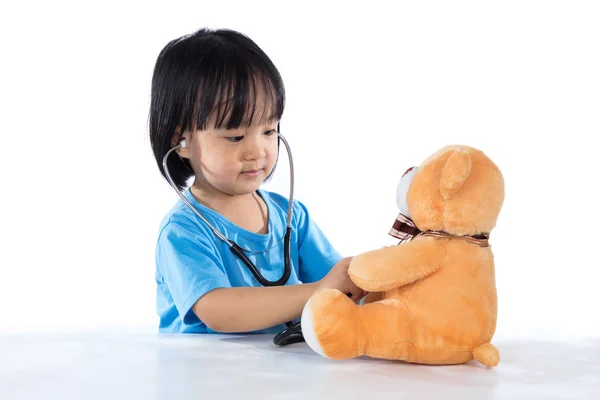 Asiatique chinois petit médecin fille examiner ours en peluche — Photo