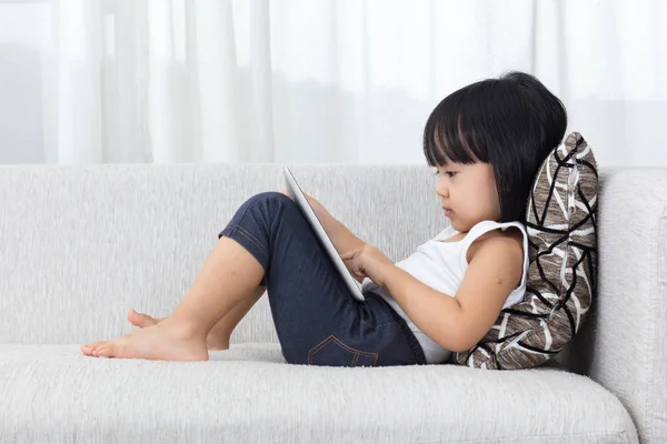 Asiática china niña acostada en el sofá con la tableta — Foto de Stock